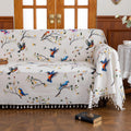 Bird Print Sofa Cover – Brighten your living space with this elegant white sofa cover adorned with colorful bird and tree branch patterns, bringing a fresh, nature-inspired touch to your décor. Crafted from soft, durable fabric with charming tassel fringe edges, it protects your couch from dust, spills, and daily wear while adding a vibrant, artistic flair. Perfect for living rooms, sunrooms, or cottages, this slipcover combines functionality with style, creating a cozy and inviting atmosphere for any seaso