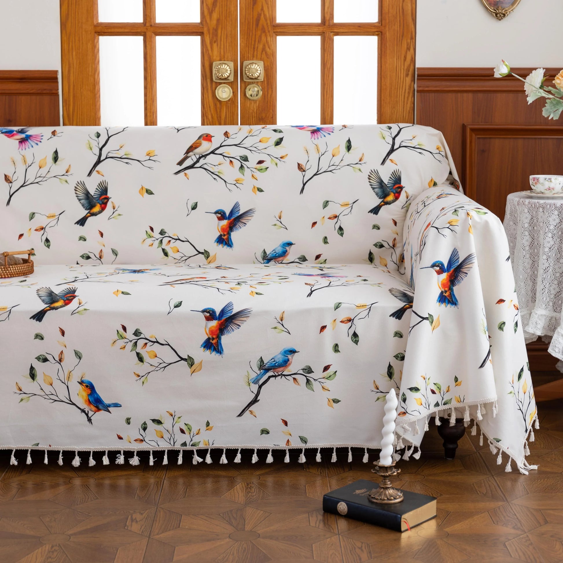 Bird Print Sofa Cover – Brighten your living space with this elegant white sofa cover adorned with colorful bird and tree branch patterns, bringing a fresh, nature-inspired touch to your décor. Crafted from soft, durable fabric with charming tassel fringe edges, it protects your couch from dust, spills, and daily wear while adding a vibrant, artistic flair. Perfect for living rooms, sunrooms, or cottages, this slipcover combines functionality with style, creating a cozy and inviting atmosphere for any seaso