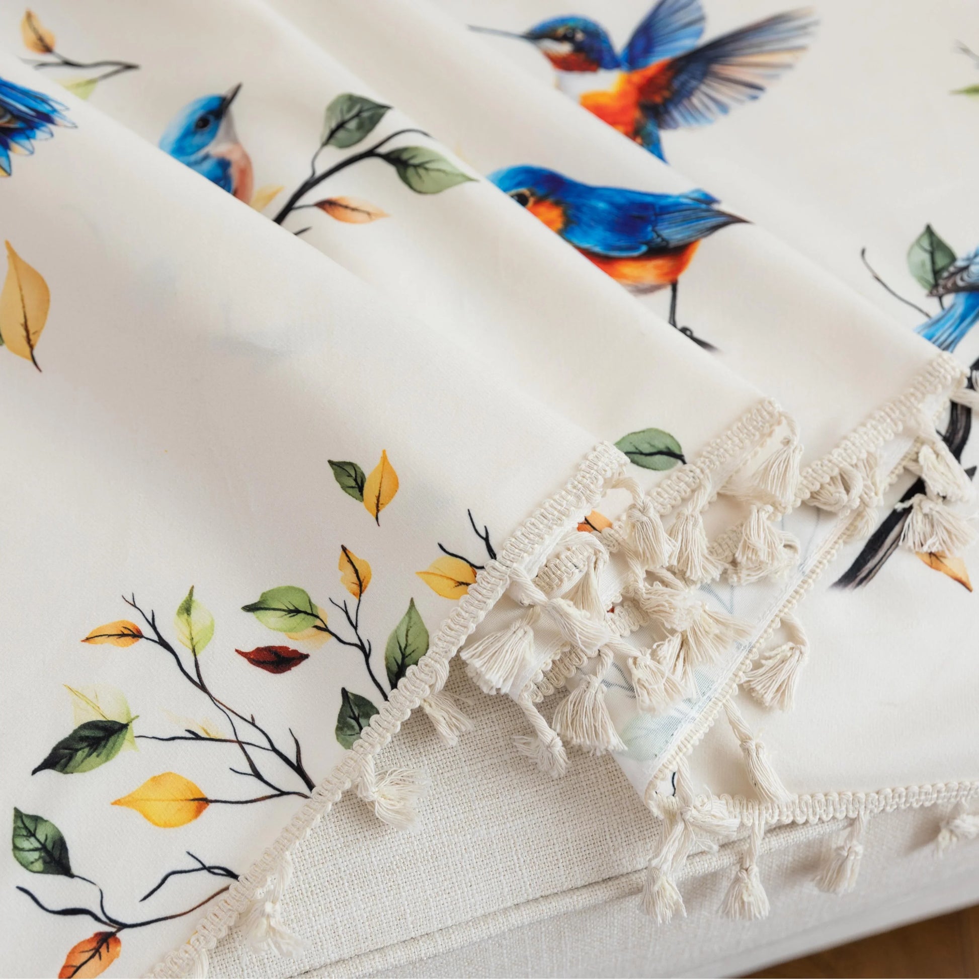 Bird Print Sofa Cover – Brighten your living space with this elegant white sofa cover adorned with colorful bird and tree branch patterns, bringing a fresh, nature-inspired touch to your décor. Crafted from soft, durable fabric with charming tassel fringe edges, it protects your couch from dust, spills, and daily wear while adding a vibrant, artistic flair. Perfect for living rooms, sunrooms, or cottages, this slipcover combines functionality with style, creating a cozy and inviting atmosphere for any seaso