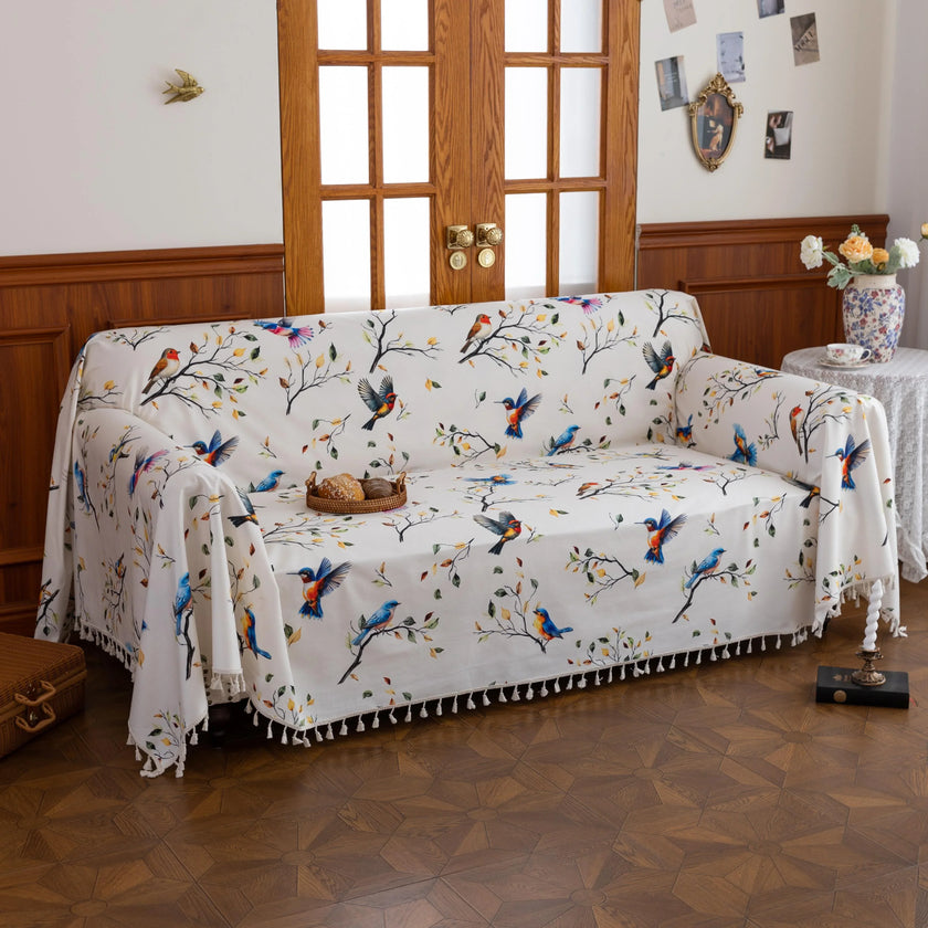 Bird Print Sofa Cover ¨C Brighten your living space with this elegant white sofa cover adorned with colorful bird and tree branch patterns, bringing a fresh, nature-inspired touch to your d¨¦cor. Crafted from soft, durable fabric with charming tassel fringe edges, it protects your couch from dust, spills, and daily wear while adding a vibrant, artistic flair. Perfect for living rooms, sunrooms, or cottages, this slipcover combines functionality with style, creating a cozy and inviting atmosphere for any sea