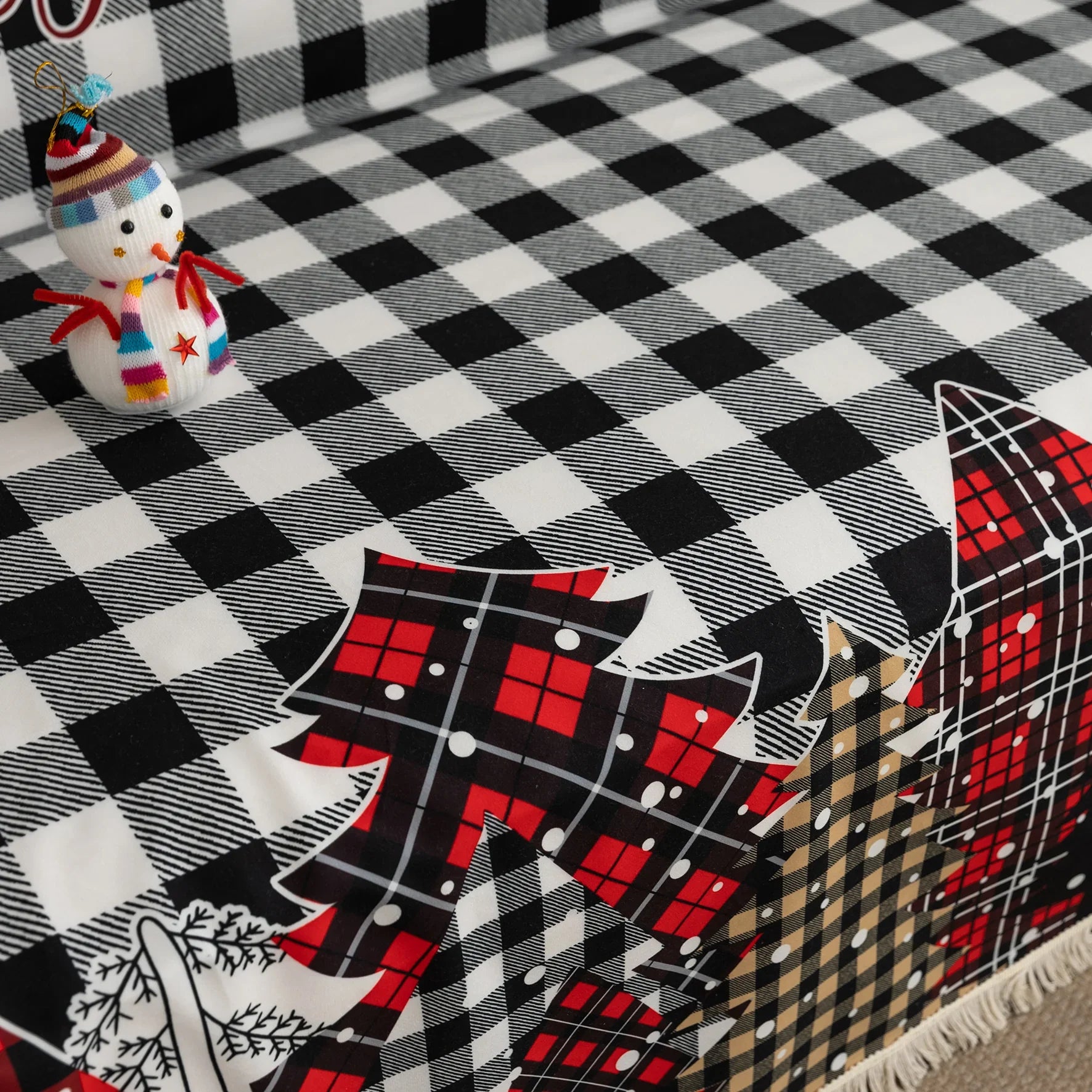 Christmas Plaid Sofa Cover – Bring holiday cheer to your home with this cozy black-and-white buffalo check sofa cover, featuring festive “Merry Christmas” lettering and colorful patchwork Christmas tree patterns in red, black, and beige tartan designs. Made from soft, durable fabric with decorative fringe edges, it protects your couch from spills, dust, and wear while adding a warm, seasonal touch. Perfect for winter décor, Christmas parties, and farmhouse-style interiors, this slipcover combines function a