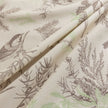 Beige sofa cover with delicate botanical and bird illustrations in brown and light green, featuring nature-inspired patterns.