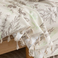 Beige sofa cover with delicate botanical and bird illustrations in brown and light green, featuring nature-inspired patterns.