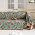 Colorful sofa cover with vibrant Moroccan-style geometric patterns in teal, red, yellow, and blue, finished with multicolor tassel trim.