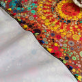 Colorful sofa cover with abstract circular and mandala-inspired patterns in vibrant shades of yellow, red, turquoise, and orange on a dark background, accented with multicolor tassel trim.