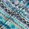 Bohemian-style sofa cover featuring vibrant blue, teal, and navy geometric tribal patterns with white tassel edging.