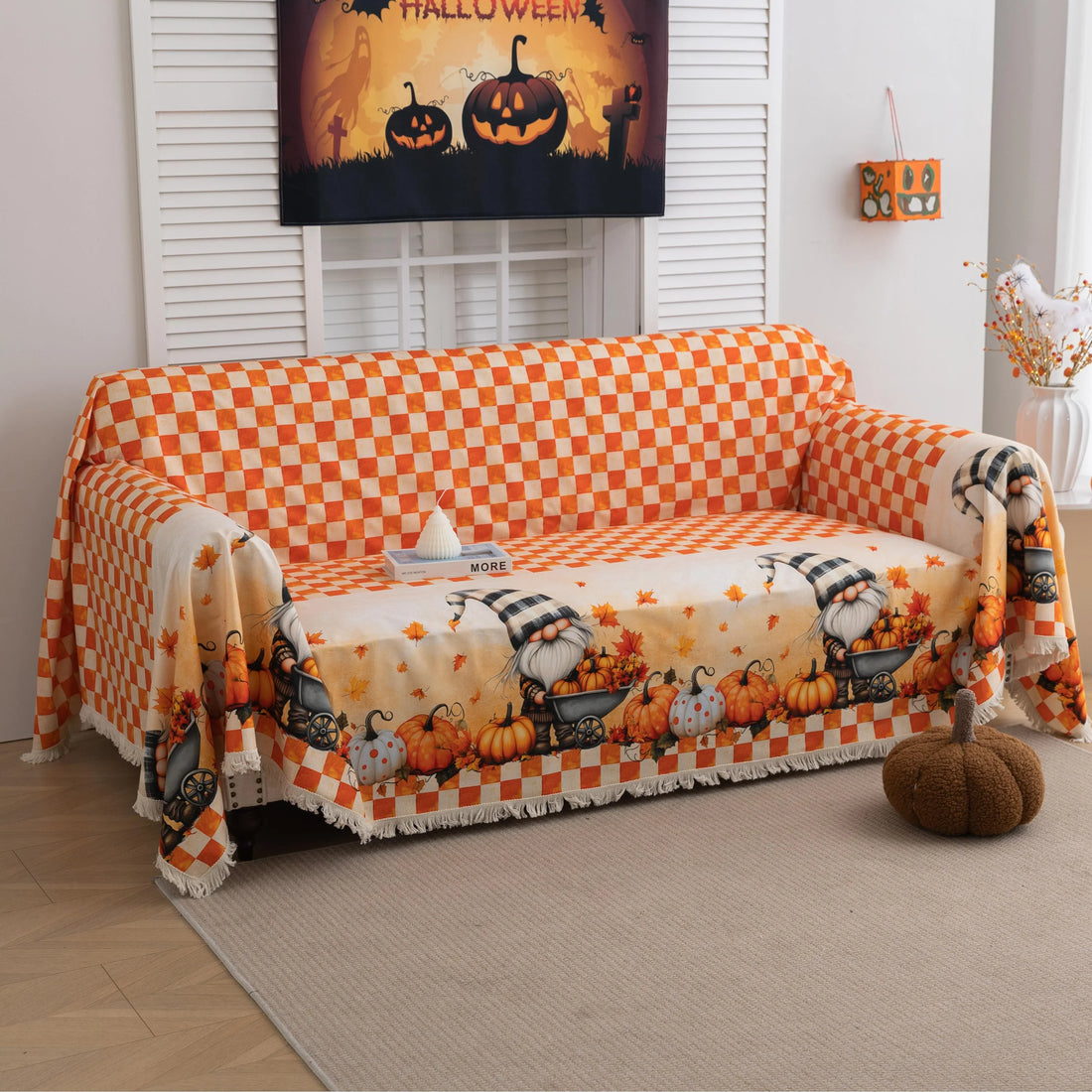 Autumn-themed sofa cover with an orange and white checkerboard pattern on the backrest and whimsical gnome illustrations on the seat, surrounded by pumpkins, leaves, and wheelbarrows, creating a cozy seasonal look.