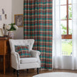 Green, red, and beige plaid curtain fabric with a soft, woven texture, finished with decorative white tassel trim along the edge.