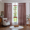 Red, navy blue, and beige plaid curtain fabric with a soft, textured weave and decorative white tassel trim on the edge.