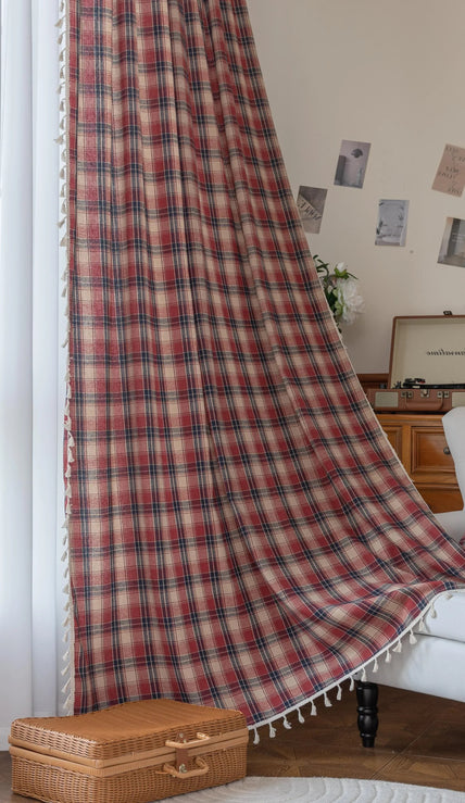 Red, navy blue, and beige plaid curtain fabric with a soft, textured weave and decorative white tassel trim on the edge.