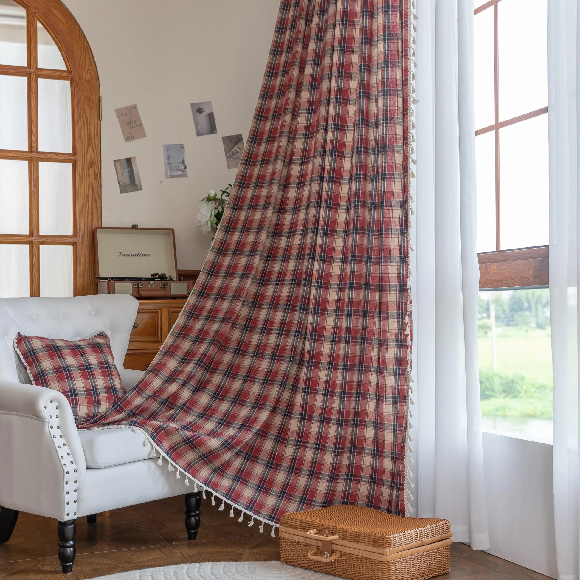 Red, navy blue, and beige plaid curtain fabric with a soft, textured weave and decorative white tassel trim on the edge.