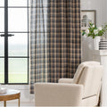 Beige and navy blue plaid curtain fabric with a soft, textured weave and decorative white tassel trim along the edge.