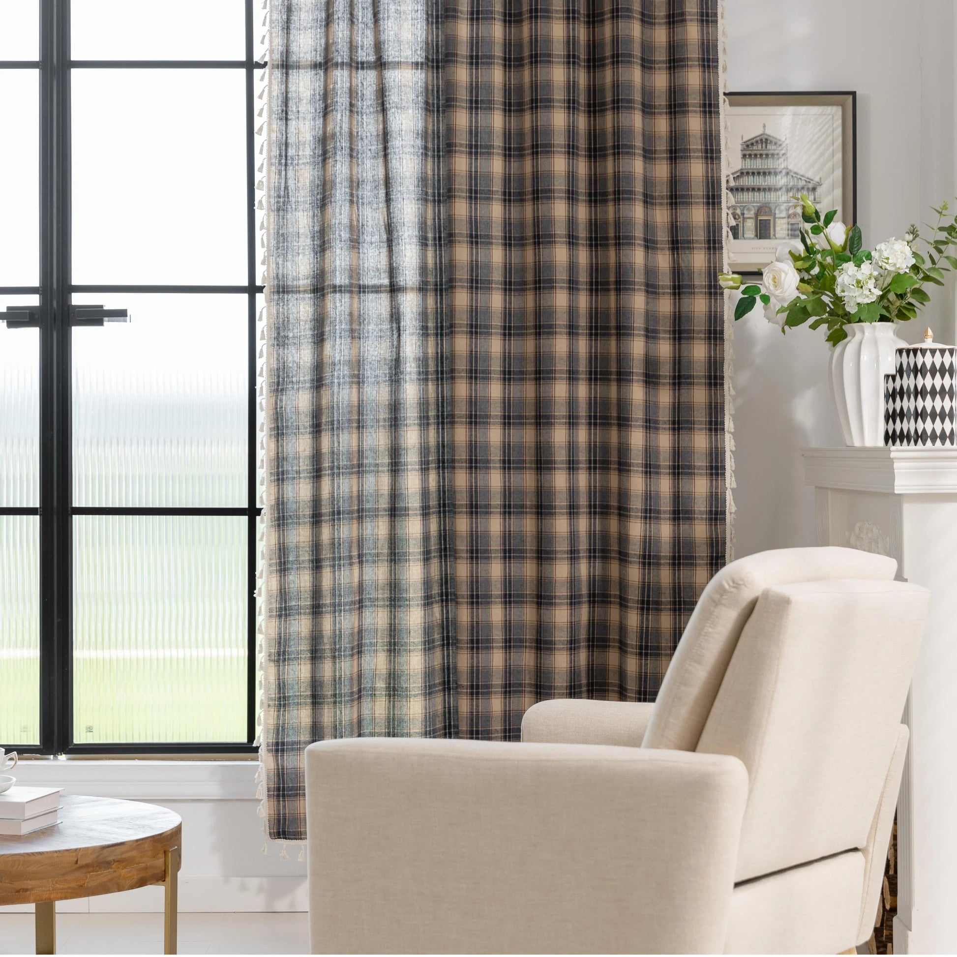 Beige and navy blue plaid curtain fabric with a soft, textured weave and decorative white tassel trim along the edge.