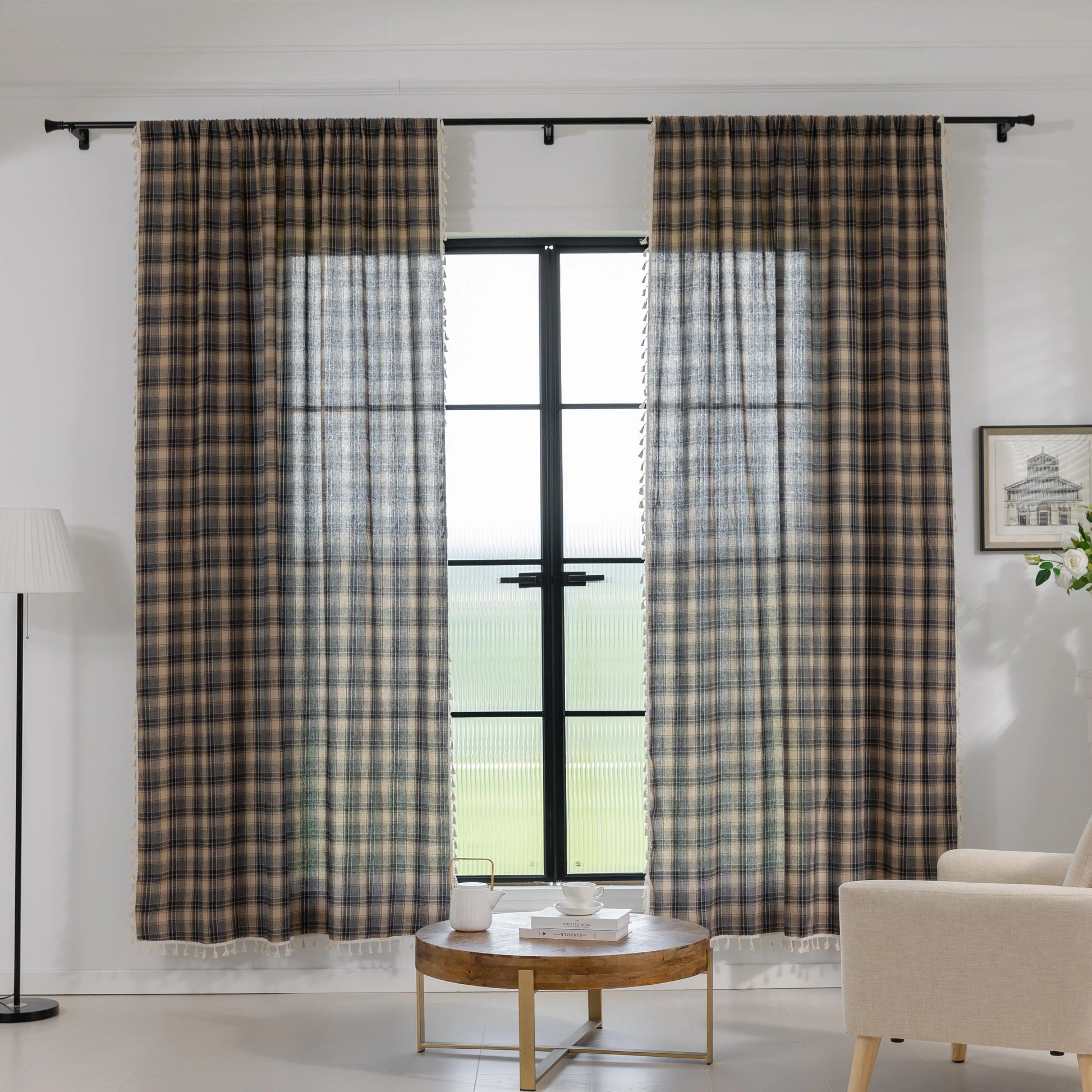 Beige and navy blue plaid curtain fabric with a soft, textured weave and decorative white tassel trim along the edge.