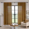 Mustard yellow and navy blue plaid curtain fabric with a soft, woven texture and decorative white tassel trim on the edge.