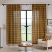 Mustard yellow and navy blue plaid curtain fabric with a soft, woven texture and decorative white tassel trim on the edge.