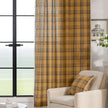 Mustard yellow and navy blue plaid curtain fabric with a soft, woven texture and decorative white tassel trim on the edge.