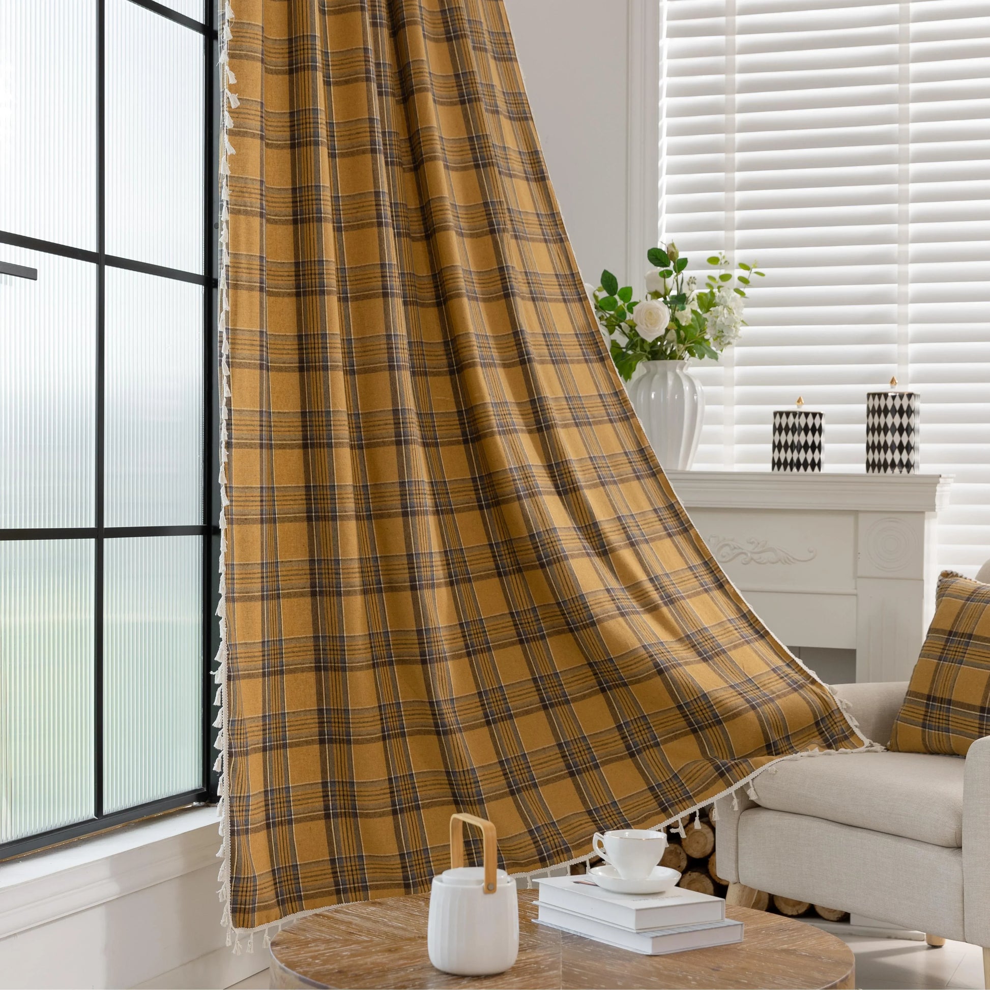 Mustard yellow and navy blue plaid curtain fabric with a soft, woven texture and decorative white tassel trim on the edge.
