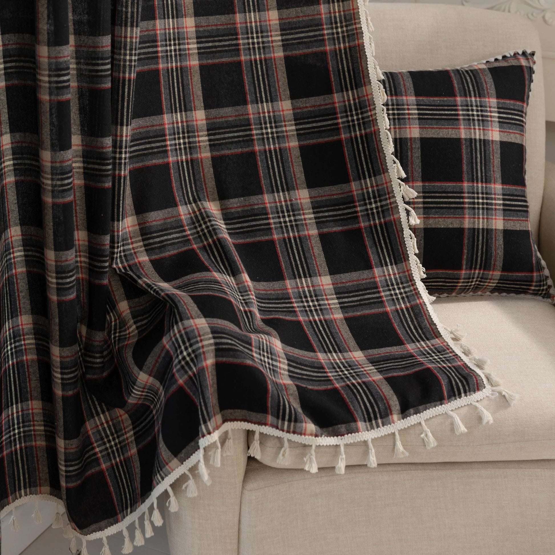Elegant black plaid curtain fabric featuring intersecting thin white and subtle red lines, creating a classic tartan pattern.