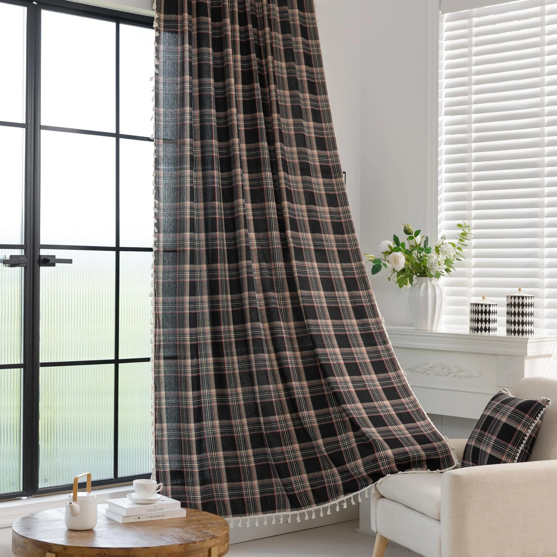 Elegant black plaid curtain fabric featuring intersecting thin white and subtle red lines, creating a classic tartan pattern.