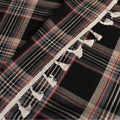Elegant black plaid curtain fabric featuring intersecting thin white and subtle red lines, creating a classic tartan pattern.