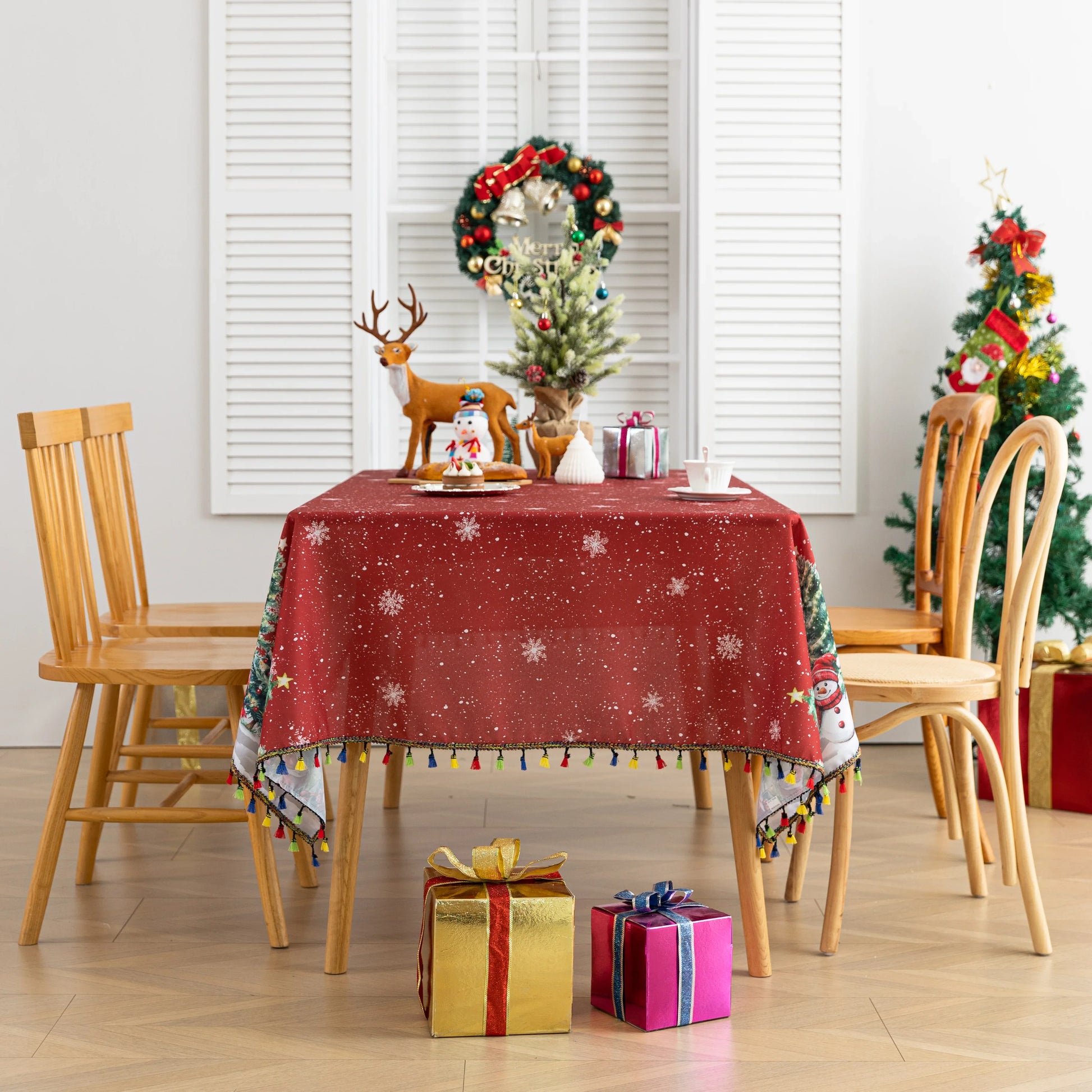 Christmas Santa Rectangular Tablecloth – Create a festive holiday atmosphere with this rectangular tablecloth featuring a snowy Christmas scene of Santa Claus, decorated pine trees, a cozy cottage, reindeer, and a cheerful snowman. Set against a rich red background with falling snowflakes and accented by playful multicolor tassels, it’s perfect for Christmas dinners, holiday parties, and seasonal home décor. Durable and eye-catching, this tablecloth brings warmth and joy to any dining space.
