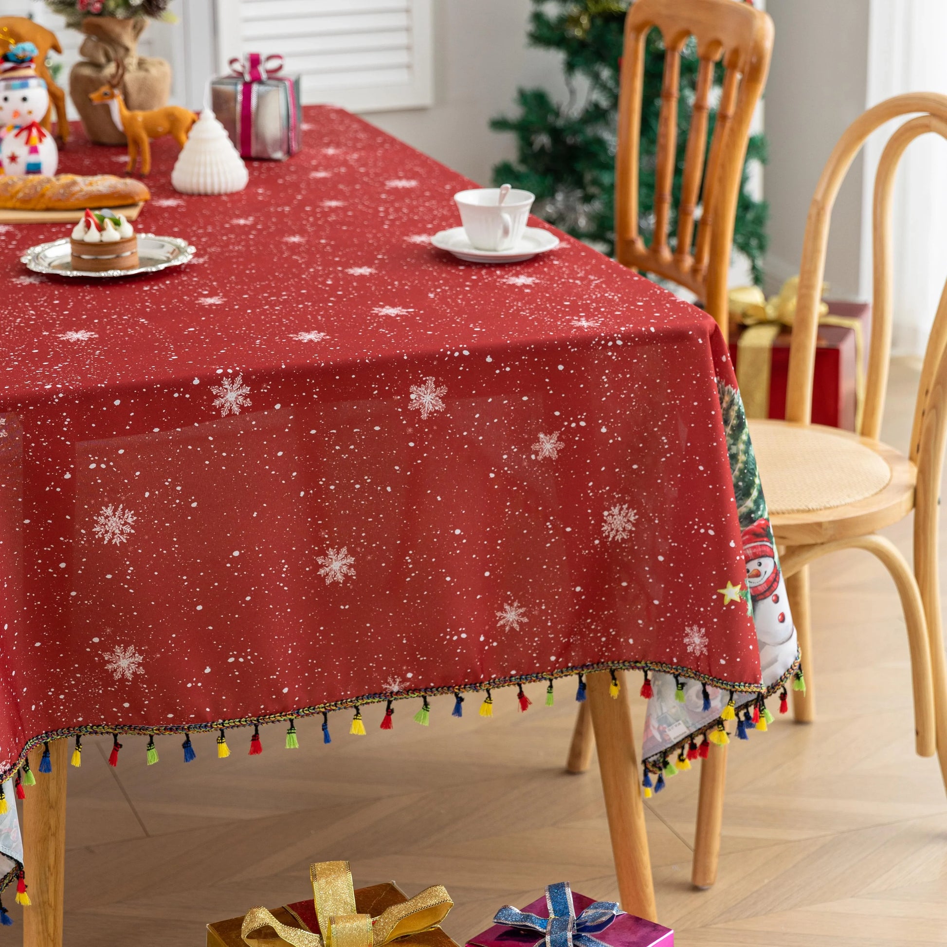 Christmas Santa Rectangular Tablecloth – Create a festive holiday atmosphere with this rectangular tablecloth featuring a snowy Christmas scene of Santa Claus, decorated pine trees, a cozy cottage, reindeer, and a cheerful snowman. Set against a rich red background with falling snowflakes and accented by playful multicolor tassels, it’s perfect for Christmas dinners, holiday parties, and seasonal home décor. Durable and eye-catching, this tablecloth brings warmth and joy to any dining space.
