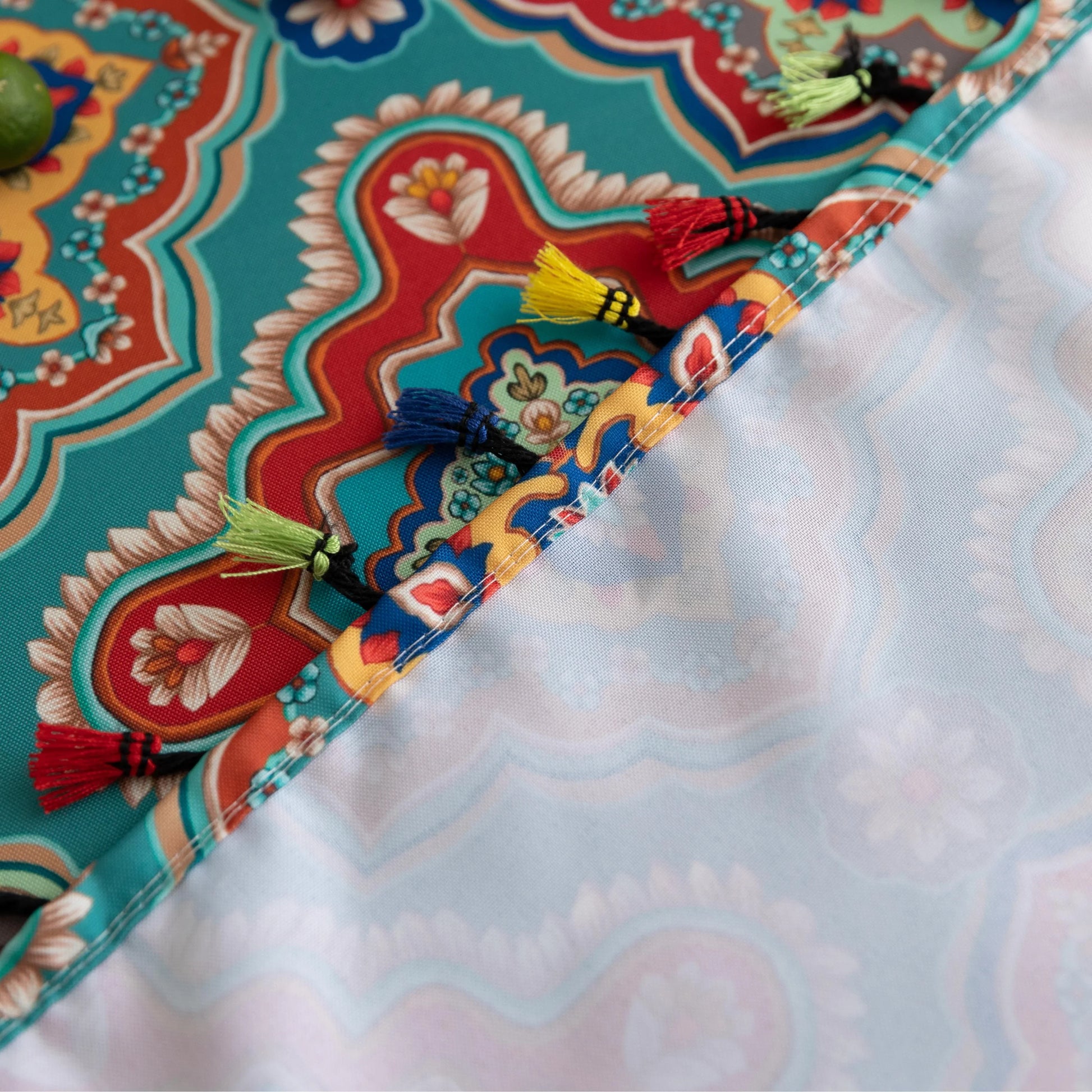 Bohemian Rectangle Tablecloth – Add vibrant charm to your dining area with this colorful round tablecloth featuring intricate Moroccan-inspired patterns in bold turquoise, red, and yellow hues. Finished with playful multicolor tassels along the edge, it brings a lively boho flair to both indoor and outdoor dining. Perfect for kitchen tables, coffee nooks, or garden parties, this durable and eye-catching tablecloth is ideal for everyday use or special occasions.
