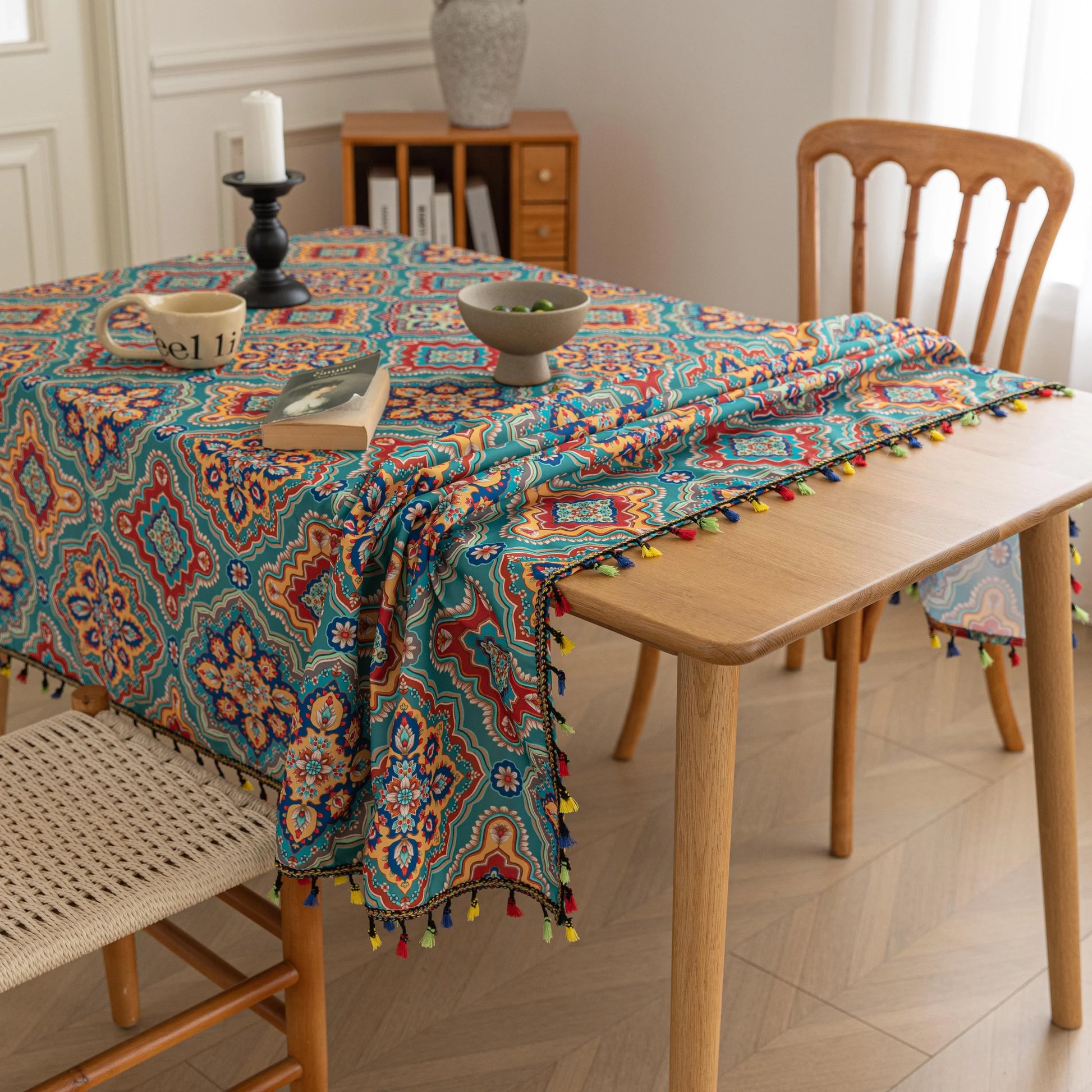 Bohemian Rectangle Tablecloth – Add vibrant charm to your dining area with this colorful round tablecloth featuring intricate Moroccan-inspired patterns in bold turquoise, red, and yellow hues. Finished with playful multicolor tassels along the edge, it brings a lively boho flair to both indoor and outdoor dining. Perfect for kitchen tables, coffee nooks, or garden parties, this durable and eye-catching tablecloth is ideal for everyday use or special occasions.
