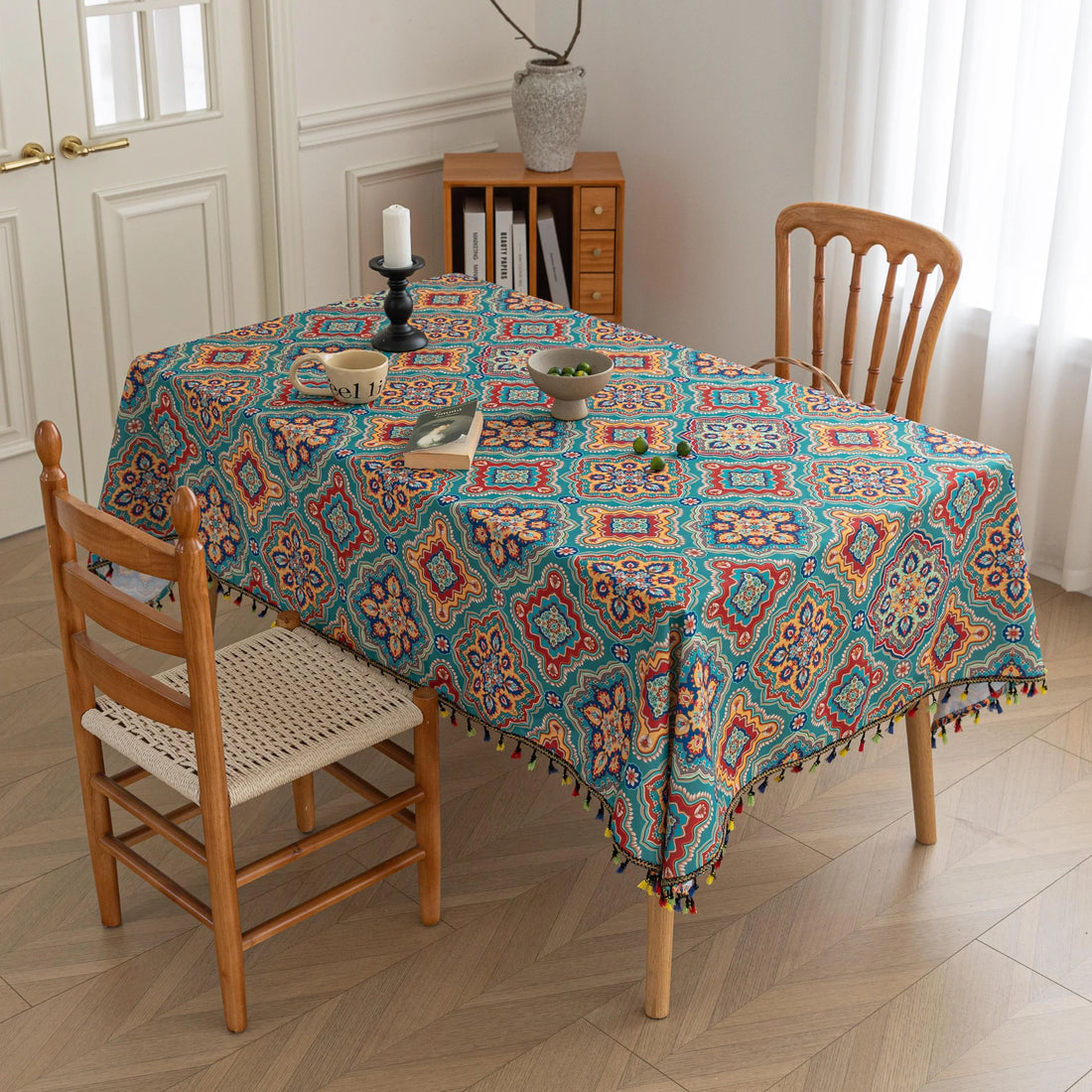 Bohemian Rectangle Tablecloth – Add vibrant charm to your dining area with this colorful round tablecloth featuring intricate Moroccan-inspired patterns in bold turquoise, red, and yellow hues. Finished with playful multicolor tassels along the edge, it brings a lively boho flair to both indoor and outdoor dining. Perfect for kitchen tables, coffee nooks, or garden parties, this durable and eye-catching tablecloth is ideal for everyday use or special occasions.
