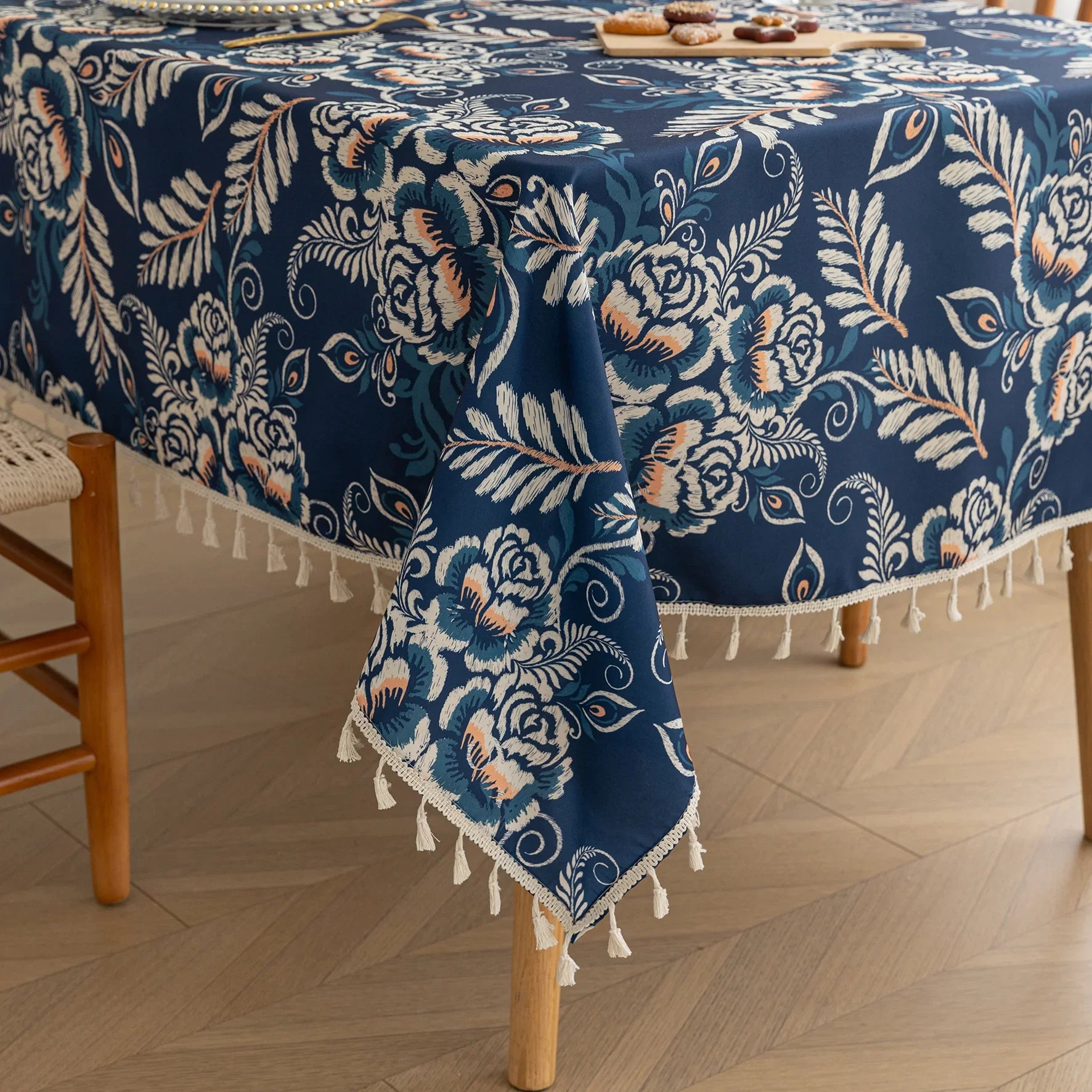 Elegant Floral RectangleTablecloth – Enhance your dining space with this stylish round tablecloth featuring a deep navy blue background adorned with delicate white and beige floral patterns. Accented with charming white tassels along the edge, it brings a refined yet cozy touch to your table décor. Perfect for everyday meals, afternoon tea, or special gatherings, this durable and decorative tablecloth suits both modern and classic interiors.
