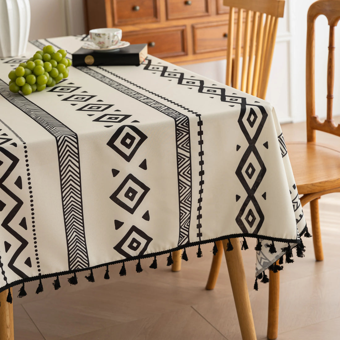Modern black and white geometric patterned tablecloth with tribal-inspired diamond and stripe designs.