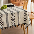 Modern black and white geometric patterned tablecloth with tribal-inspired diamond and stripe designs.