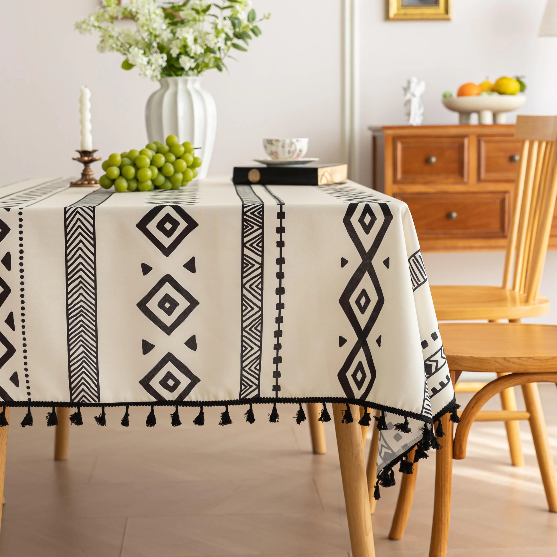 Modern black and white geometric patterned tablecloth with tribal-inspired diamond and stripe designs.