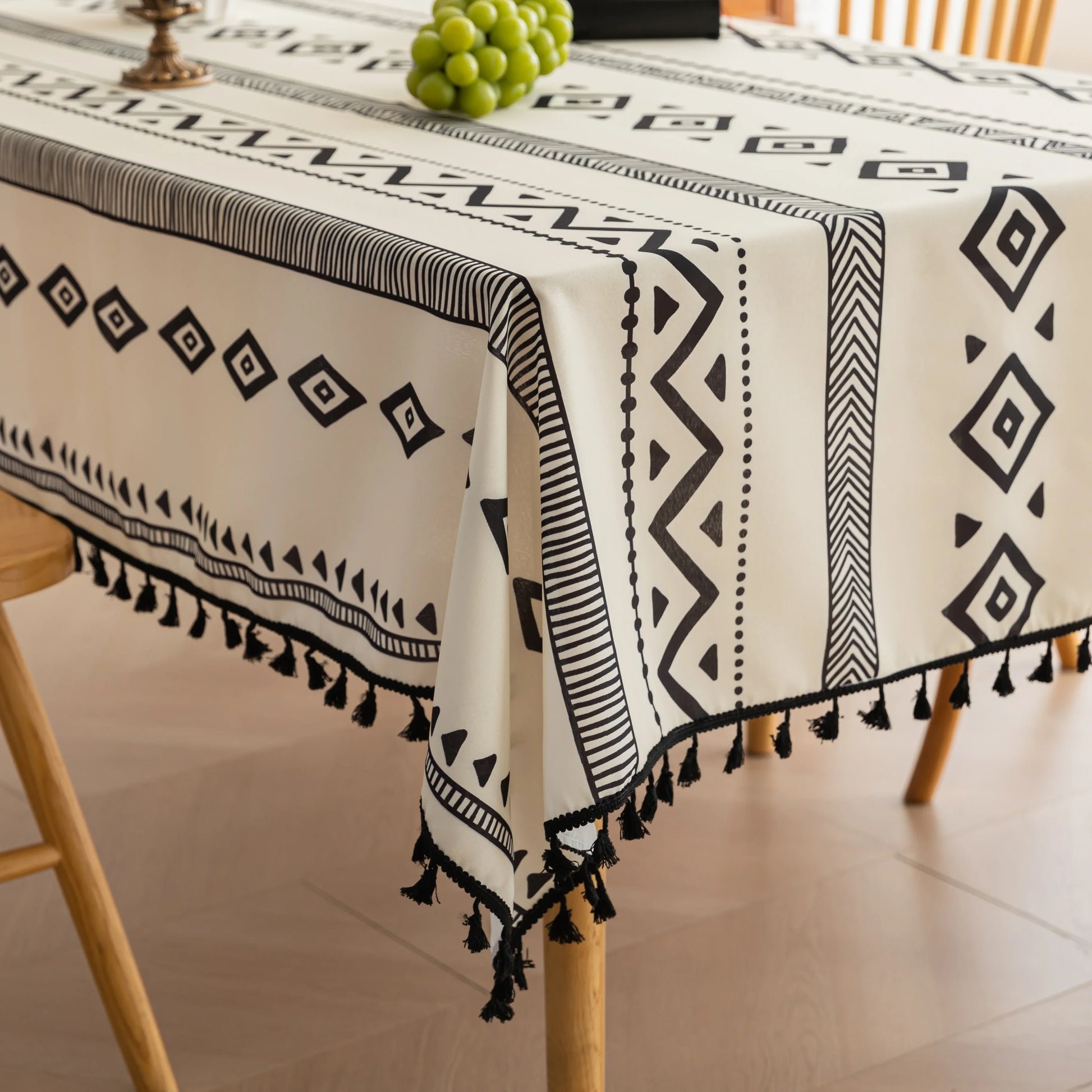 Modern black and white geometric patterned tablecloth with tribal-inspired diamond and stripe designs.