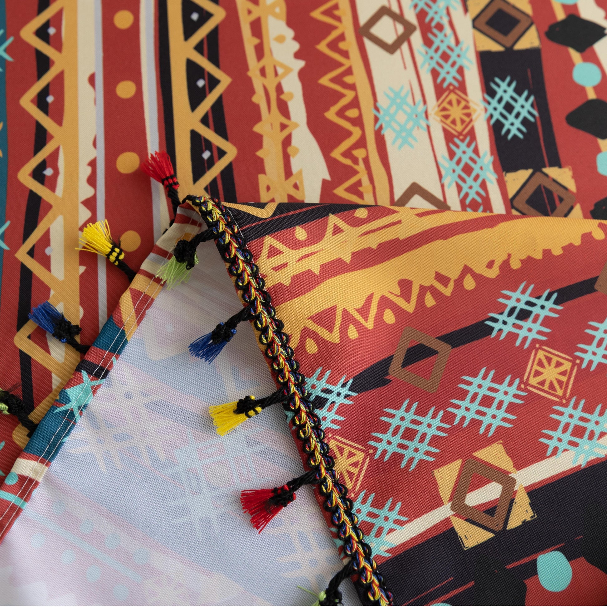 Vibrant bohemian tablecloth with colorful geometric patterns and playful tassel trim — perfect for adding warmth and personality to dining tables, picnics, and festive gatherings.
