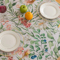 Elegant floral tablecloth with lush green leaves and soft pastel blossoms, accented by delicate tassel edging — perfect for adding a fresh, nature-inspired touch to dining rooms, garden parties, or spring gatherings.