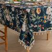 Chic dark floral tablecloth featuring vibrant botanical prints on a deep navy background, finished with elegant tassel edges ¡ª ideal for elevating dining d¨¦cor, special occasions, and stylish everyday meals.