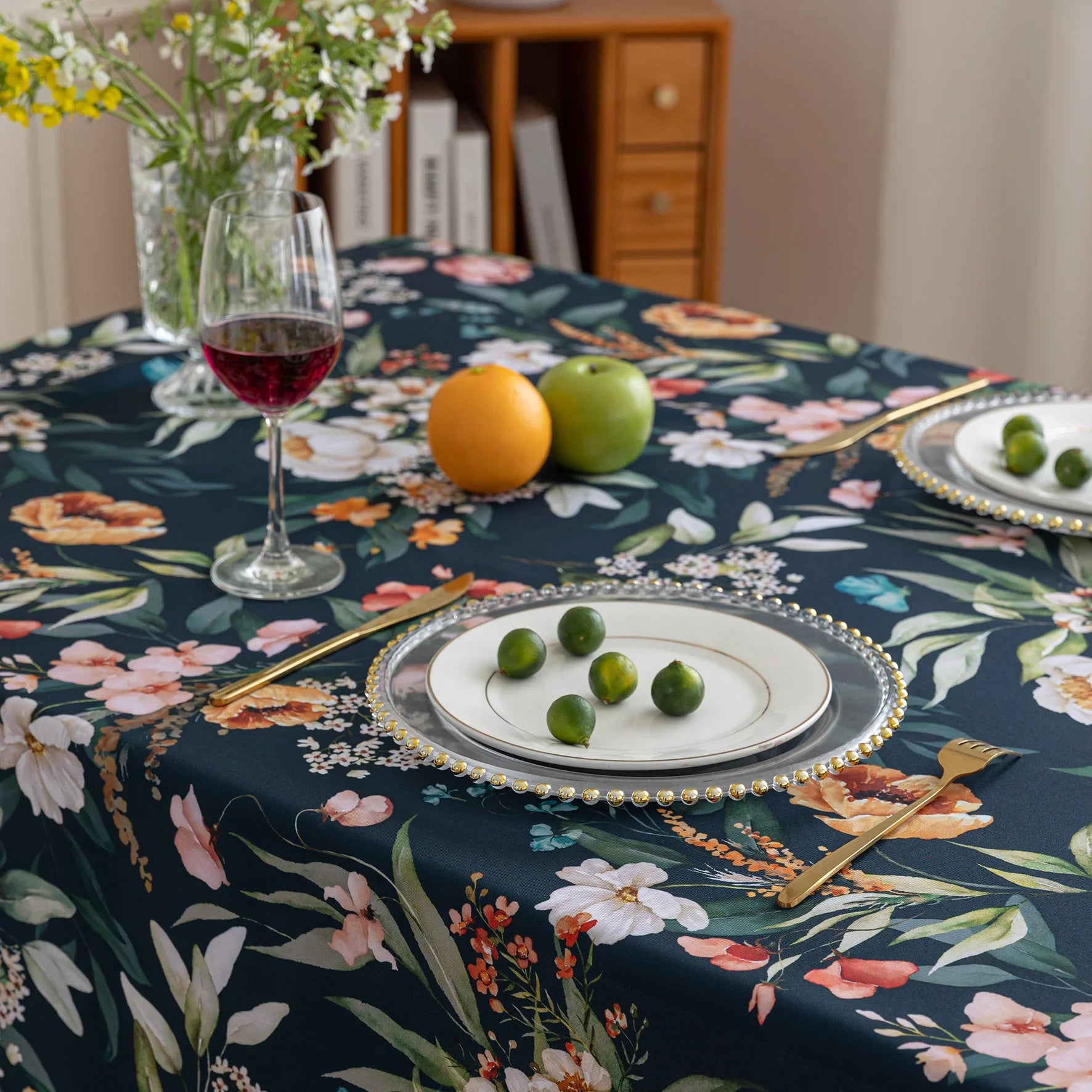Chic dark floral tablecloth featuring vibrant botanical prints on a deep navy background, finished with elegant tassel edges — ideal for elevating dining décor, special occasions, and stylish everyday meals.