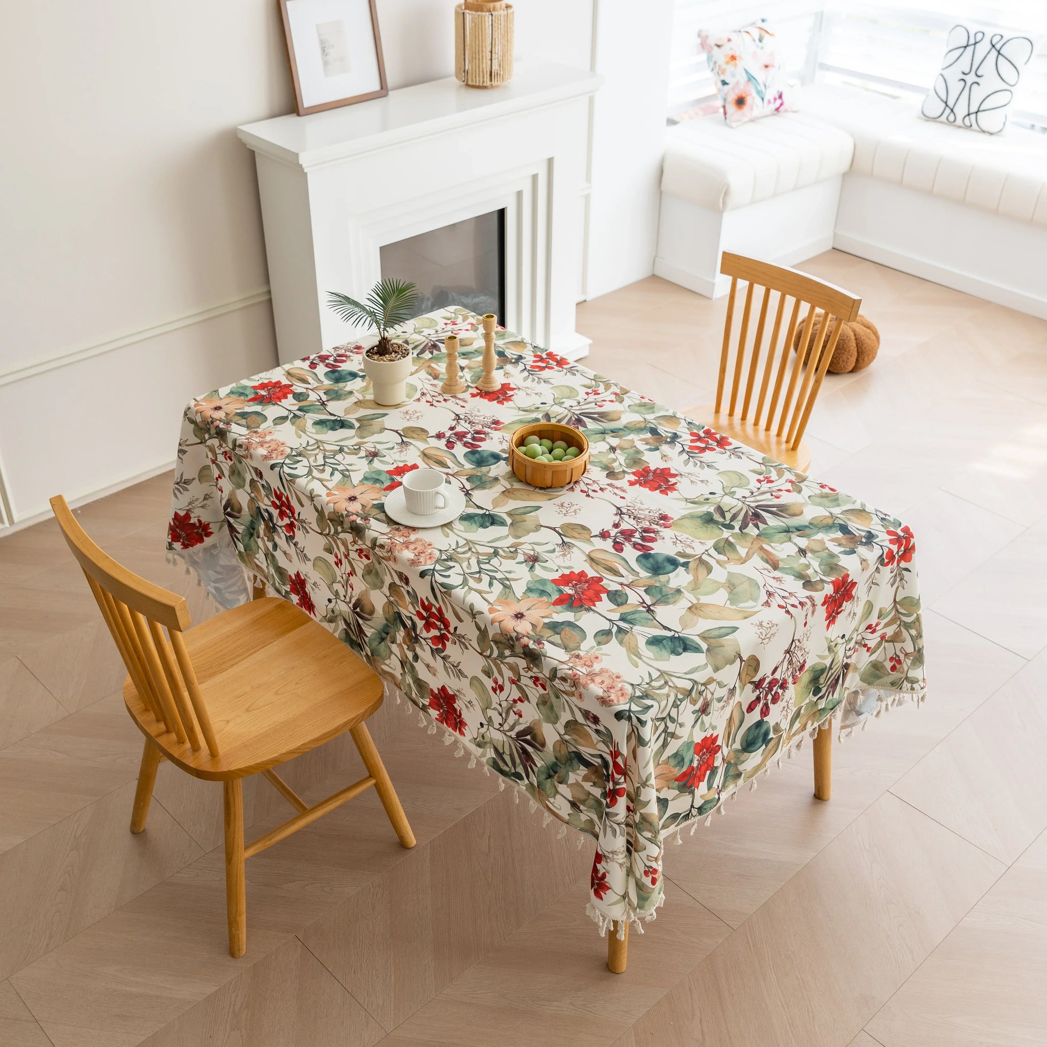 Beautiful floral tablecloth with vibrant red, green, and beige botanical patterns, enhanced by delicate tassel edging — perfect for adding a warm, inviting touch to everyday dining or festive gatherings.