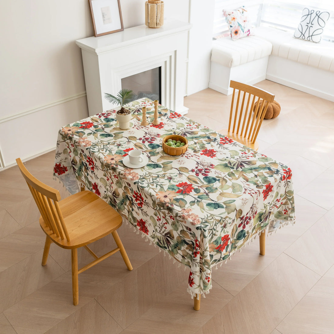 Beautiful floral tablecloth with vibrant red, green, and beige botanical patterns, enhanced by delicate tassel edging — perfect for adding a warm, inviting touch to everyday dining or festive gatherings.