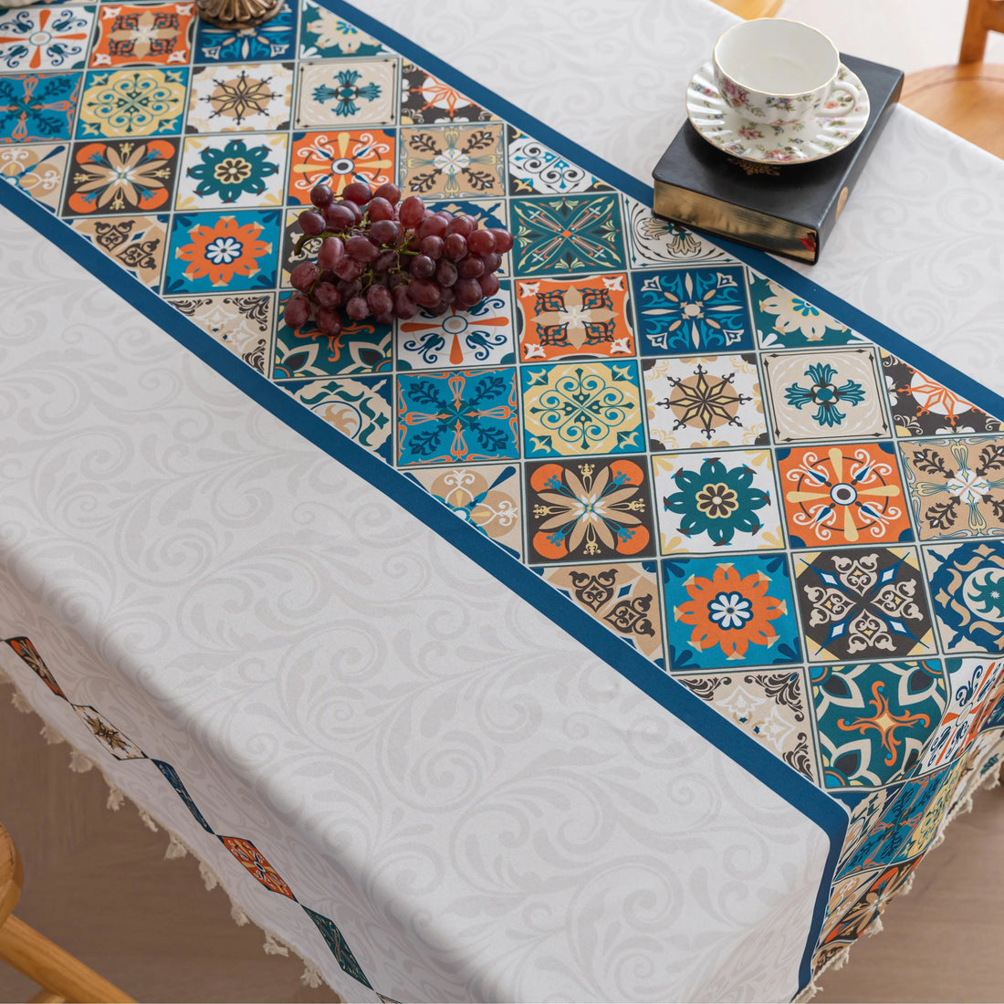 Elegant boho-style tablecloth with colorful geometric patterns and tassels, perfect for adding charm and protecting your dining table.
