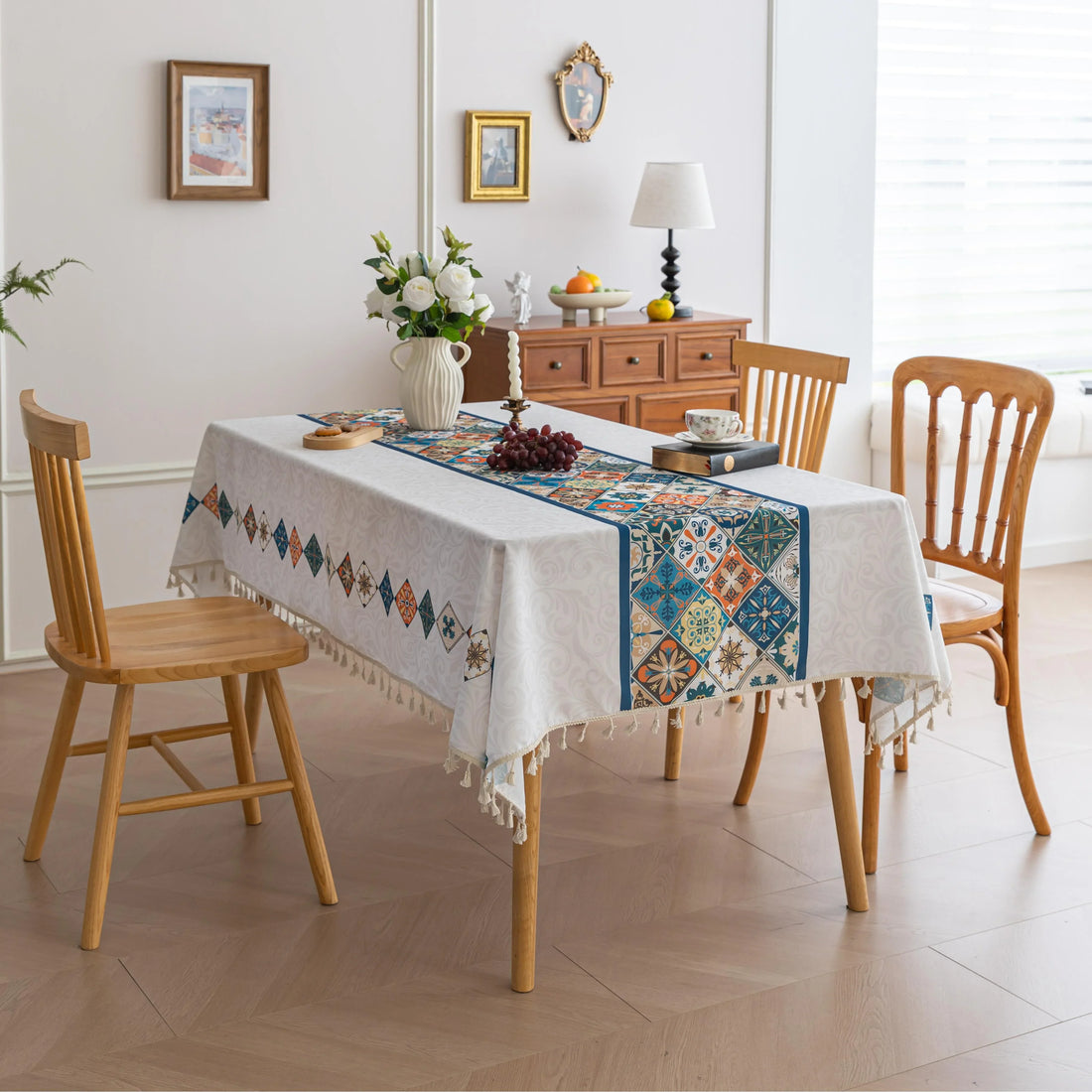 Elegant boho-style tablecloth with colorful geometric patterns and tassels, perfect for adding charm and protecting your dining table.