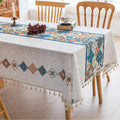 Elegant boho-style tablecloth with colorful geometric patterns and tassels, perfect for adding charm and protecting your dining table.