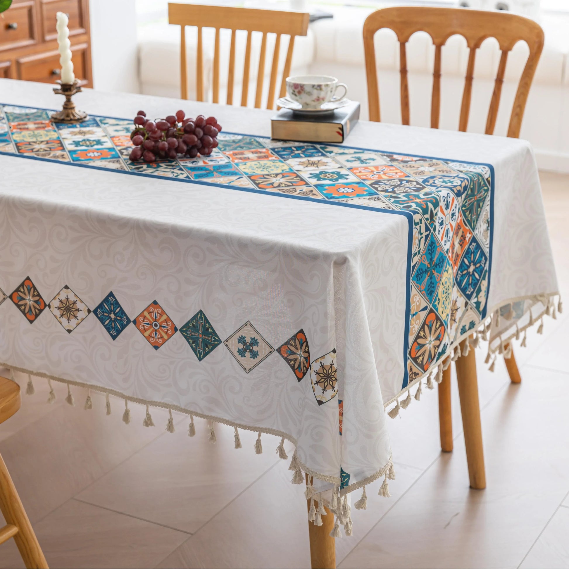 Elegant boho-style tablecloth with colorful geometric patterns and tassels, perfect for adding charm and protecting your dining table.