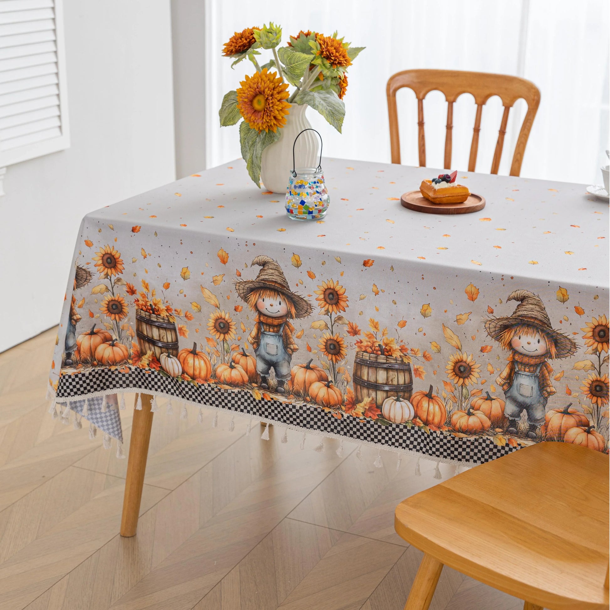 Autumn Harvest Rectangular Tablecloth – Add seasonal charm to your dining space with this festive rectangular tablecloth featuring a delightful harvest design of pumpkins, sunflowers, wooden barrels, and a friendly scarecrow. Accented with a black-and-white checkered border and finished with cream tassels, it brings a cozy farmhouse feel to your table. Perfect for fall gatherings, Thanksgiving dinners, and rustic home décor, this durable and vibrant tablecloth enhances any seasonal celebration.
