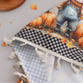 Autumn Harvest Rectangular Tablecloth – Add seasonal charm to your dining space with this festive rectangular tablecloth featuring a delightful harvest design of pumpkins, sunflowers, wooden barrels, and a friendly scarecrow. Accented with a black-and-white checkered border and finished with cream tassels, it brings a cozy farmhouse feel to your table. Perfect for fall gatherings, Thanksgiving dinners, and rustic home décor, this durable and vibrant tablecloth enhances any seasonal celebration.
