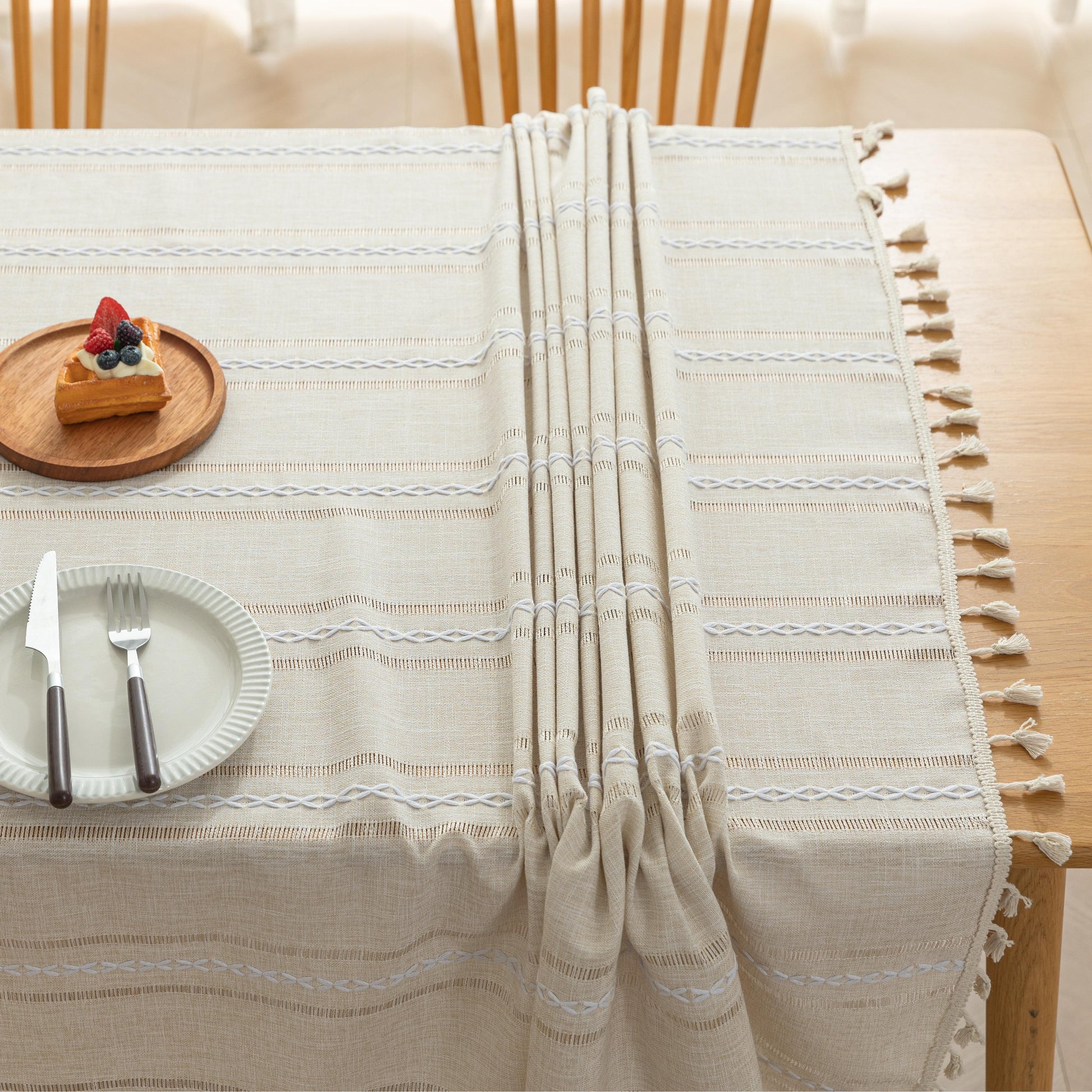 Beige Linen Tassel Tablecloth – Elevate your dining area with this elegant beige tablecloth, crafted from a soft linen-blend fabric for a natural, breathable feel. Featuring subtle white woven stripes and charming tassel edges, it adds a touch of rustic sophistication to both casual meals and festive gatherings. Durable, easy to maintain, and versatile in style, this tablecloth blends seamlessly with farmhouse, bohemian, or modern home décor while protecting your table in timeless fashion.
