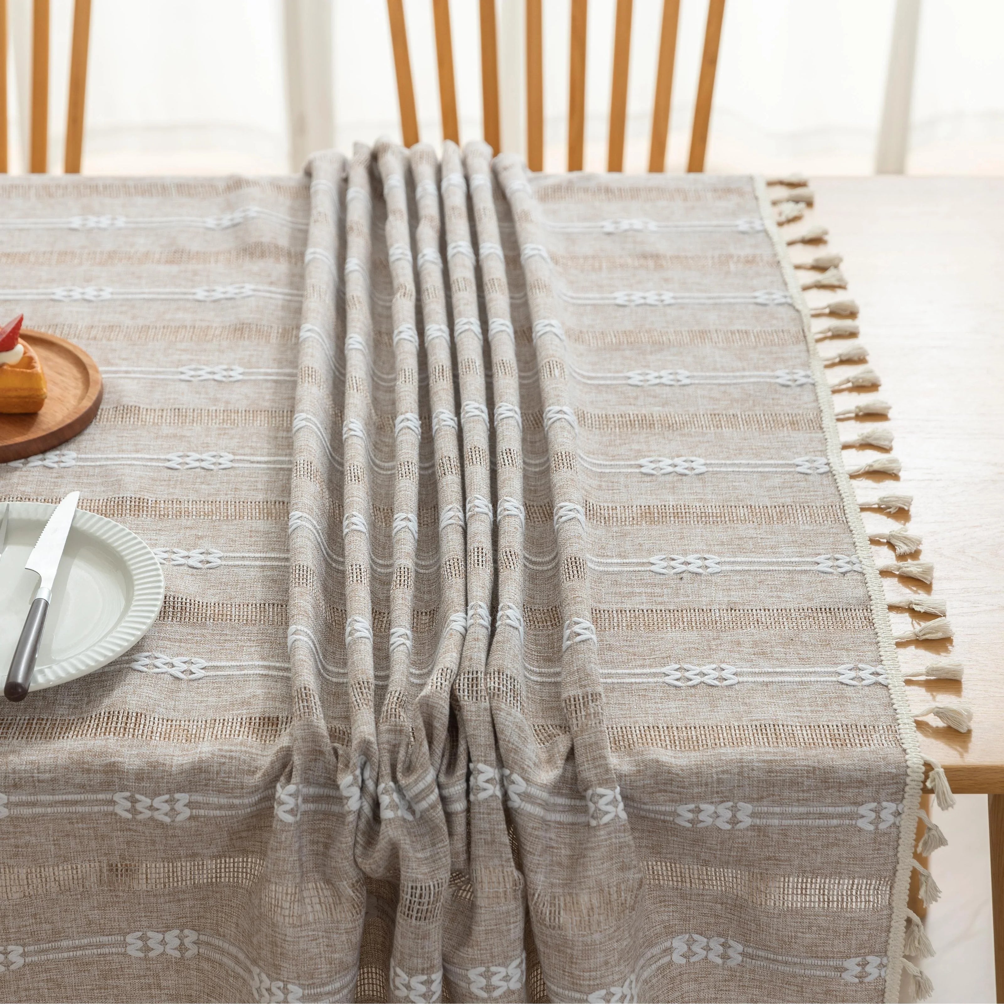 Rustic Linen Tassel Tablecloth ¨C Add a touch of natural elegance to your dining space with this beautiful linen-blend tablecloth, featuring delicate white embroidered stripes and charming tassel edging. Its neutral beige tone effortlessly complements farmhouse, bohemian, and modern interiors, making it perfect for everyday meals or special gatherings. Durable, soft, and easy to clean, this tablecloth not only protects your table but also enhances your dining experience with timeless style and texture.
