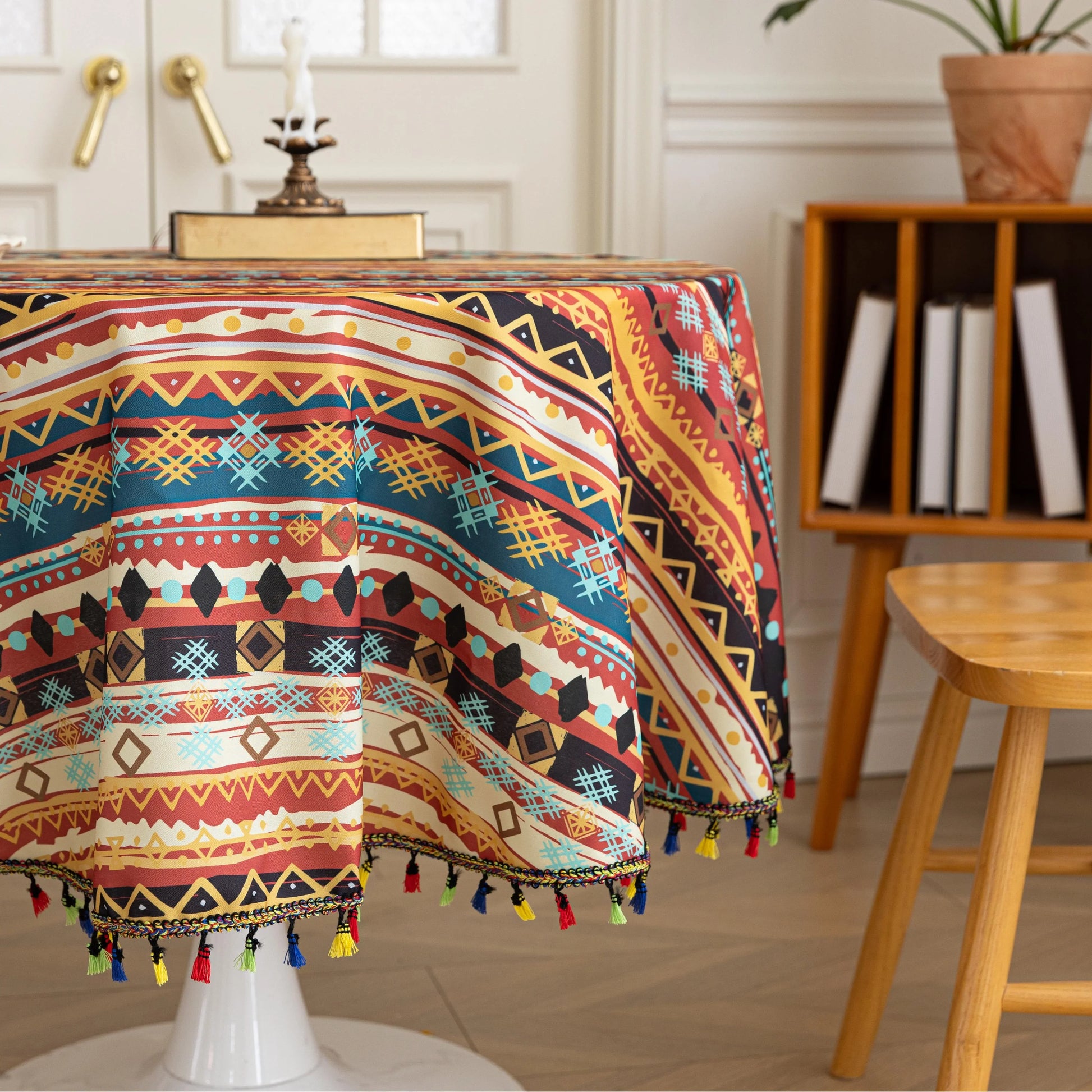 Bohemian Striped Round Tablecloth – Infuse your dining area with vibrant personality using this colorful round tablecloth featuring bold boho-inspired stripes and geometric patterns in rich red, yellow, turquoise, and black tones. Accented with playful multicolor tassels along the edge, it adds a lively and artistic touch to any table setting. Perfect for kitchen tables, coffee nooks, picnics, or festive gatherings, this durable and eye-catching tablecloth is ideal for both everyday use and special occasion